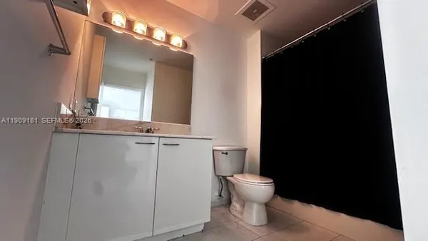 a bathroom with a toilet and a mirror