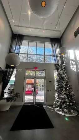 a living room with a large window and chandelier