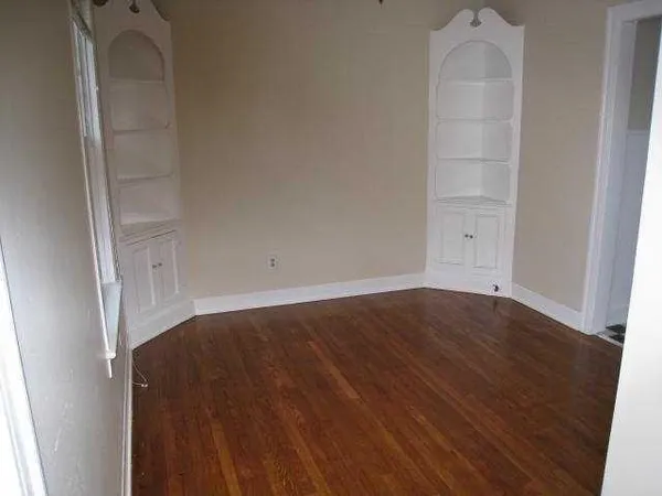 an empty room with wooden floor and closet