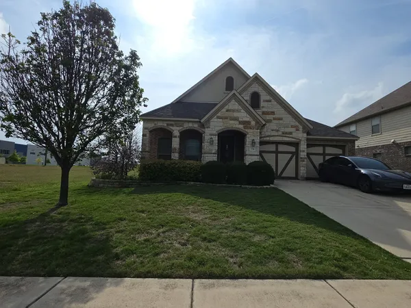 a front view of a house with a garden