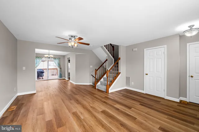 a view of a livingroom with wooden floor and a ceiling fan