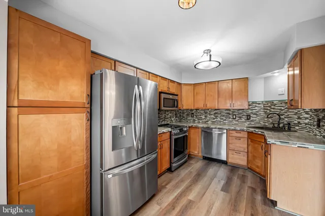 a kitchen with stainless steel appliances granite countertop a refrigerator and a sink