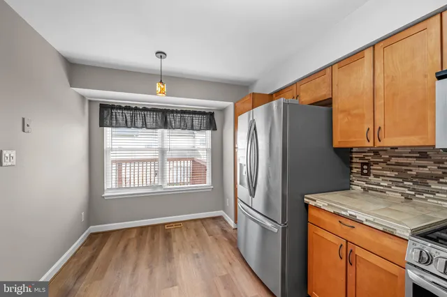 a kitchen with a refrigerator a sink and dishwasher with wooden floor