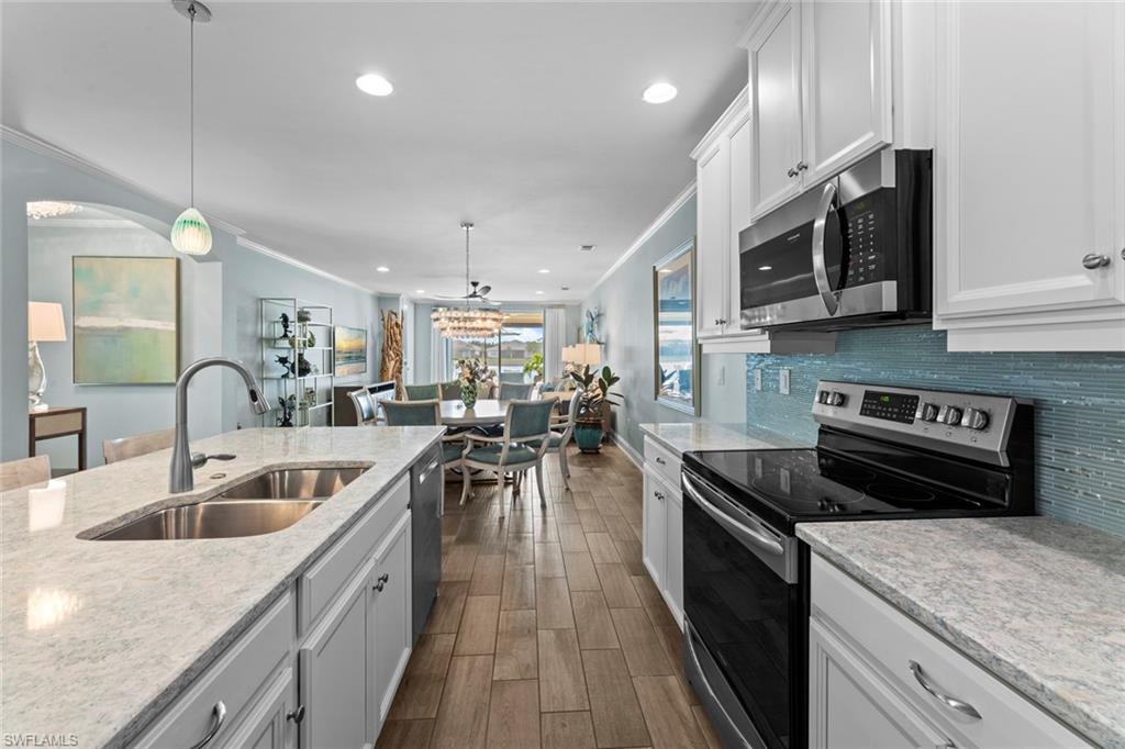14904 Edgewater Circle Naples, FL 34114 - Photo 12 of 50 a kitchen with stainless steel appliances granite countertop a sink dishwasher a stove and a microwave oven with cabinets