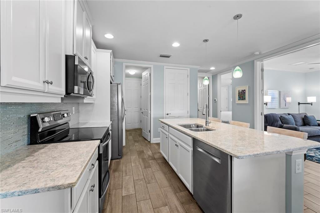 14904 Edgewater Circle Naples, FL 34114 - Photo 14 of 50 a kitchen with stainless steel appliances granite countertop a sink stove and refrigerator