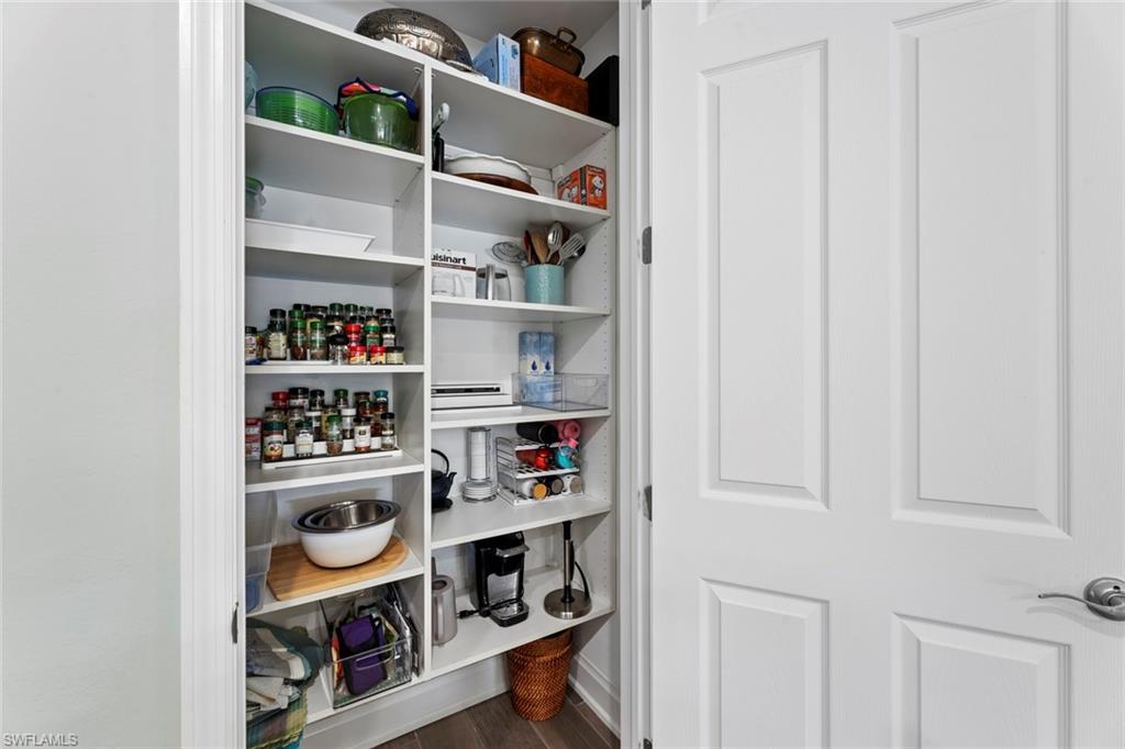 14904 Edgewater Circle Naples, FL 34114 - Photo 15 of 50 a room with a book shelf and a wooden floor