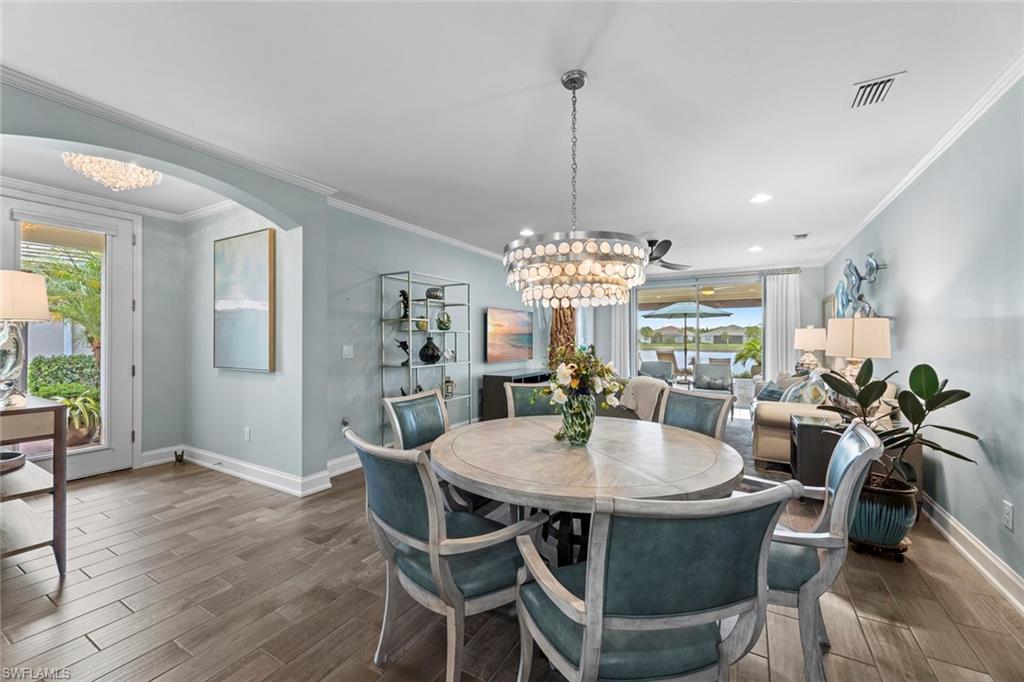 14904 Edgewater Circle Naples, FL 34114 - Photo 6 of 50 a view of a dining room with furniture a chandelier and wooden floor