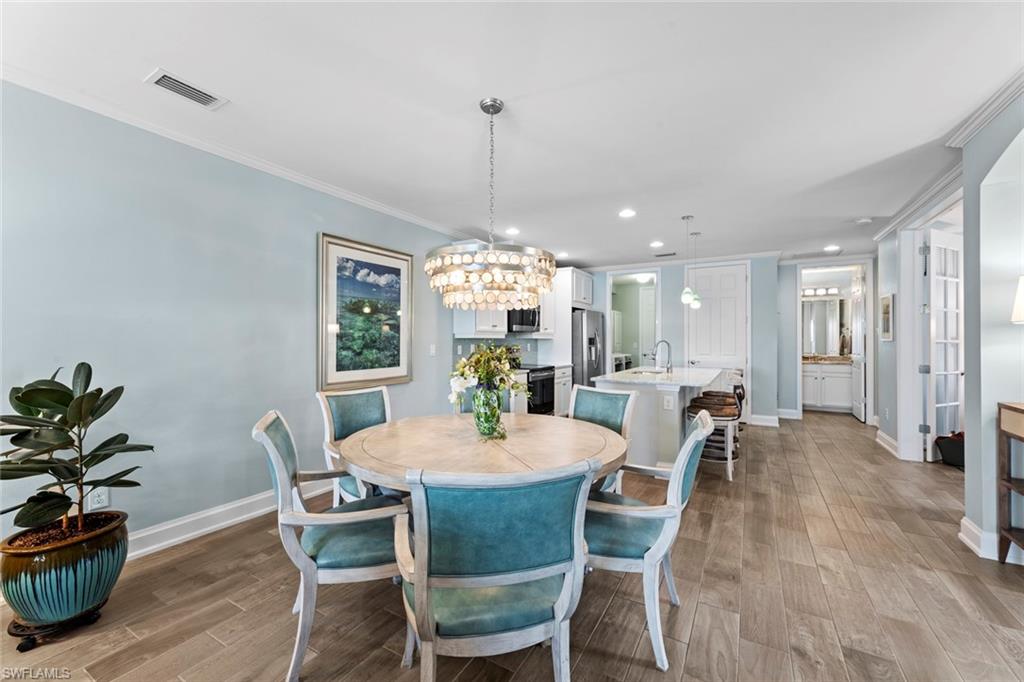 14904 Edgewater Circle Naples, FL 34114 - Photo 7 of 50 a dining room with furniture a chandelier and wooden floor