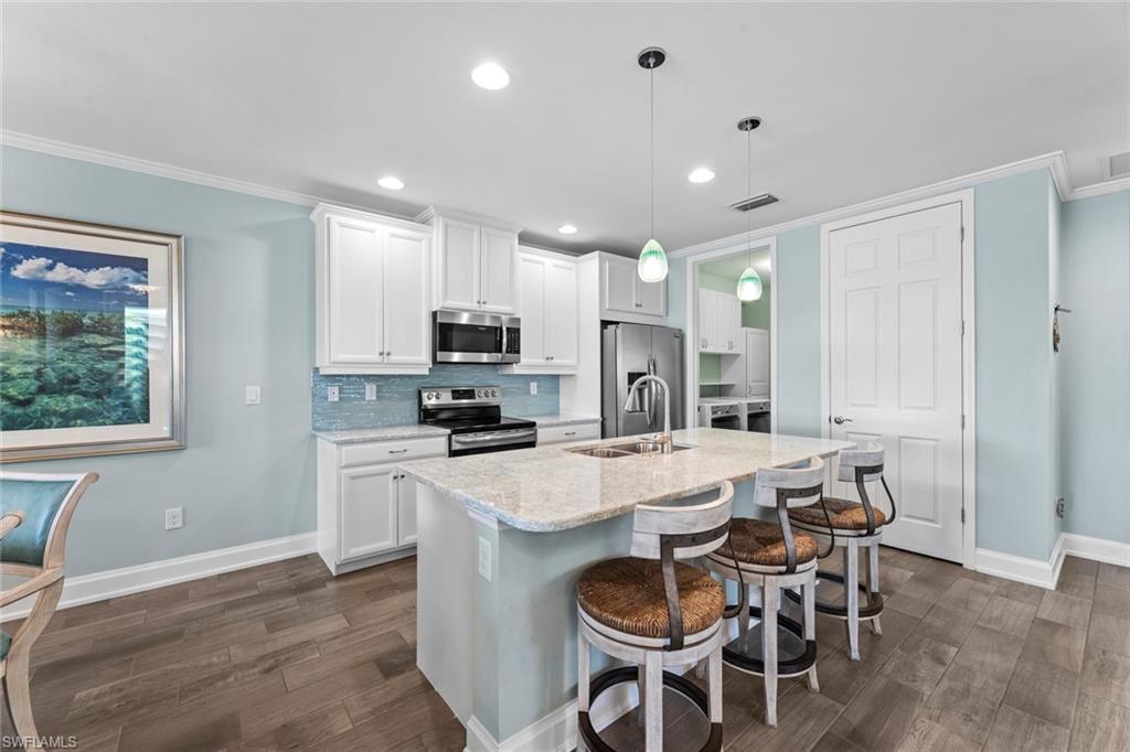 14904 Edgewater Circle Naples, FL 34114 - Photo 9 of 50 a kitchen with kitchen island wooden cabinets and counter space