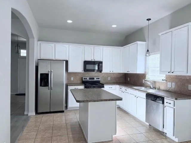 a kitchen with stainless steel appliances granite countertop a sink counter space cabinets and a refrigerator