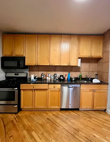 a kitchen with stainless steel appliances granite countertop a stove a sink and a microwave