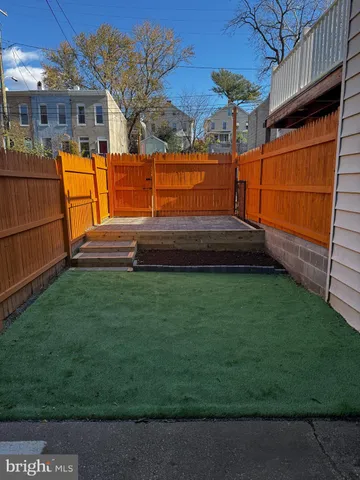 a view of backyard with wooden fence