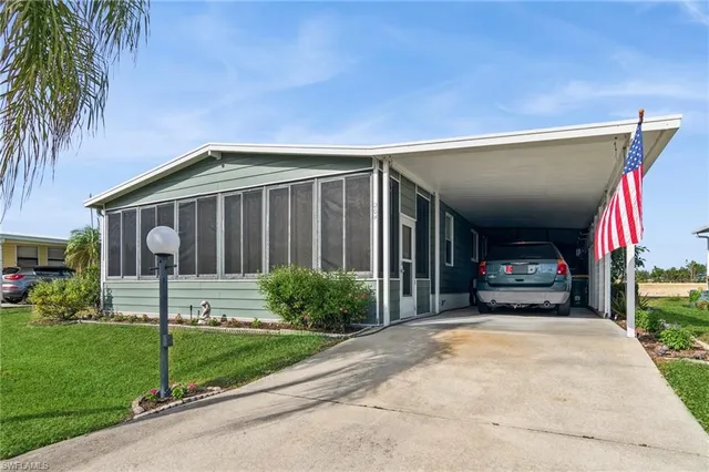 a view of a house with small yard plants and palm trees