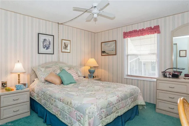 a bedroom with a bed and a window with dresser