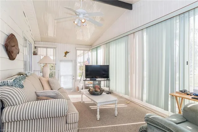 a living room with furniture a large window and chandelier