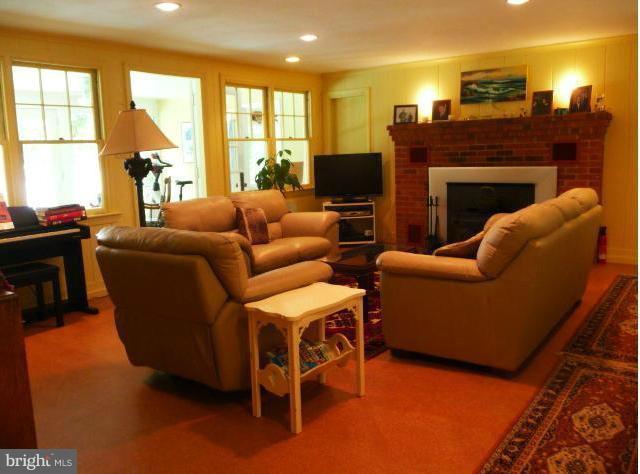 1201 Daves Road Edgewater, MD 21037 - Photo 22 of 30 a living room with furniture a fireplace and a flat screen tv