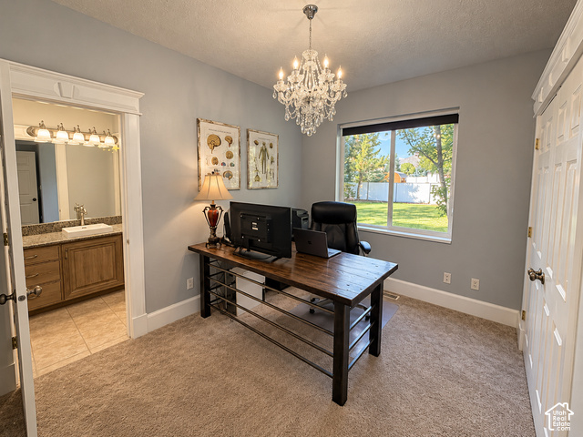 1750 West 4100 North Helper, UT 84526 - Photo 17 of 50 Elegant home office featuring a spacious desk with metal frame and shelving, crystal chandelier, soft gray walls, carpet flooring, and large windows with natural light