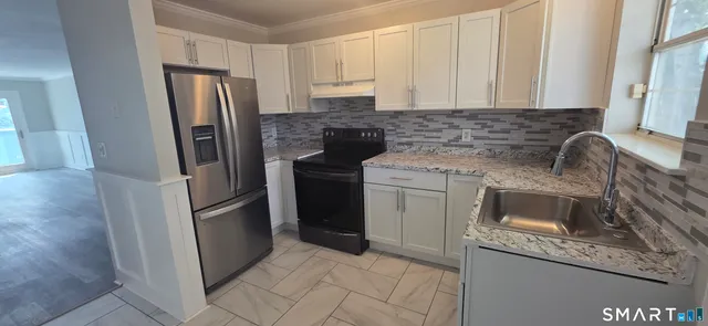 a kitchen with stainless steel appliances granite countertop a refrigerator sink and stove
