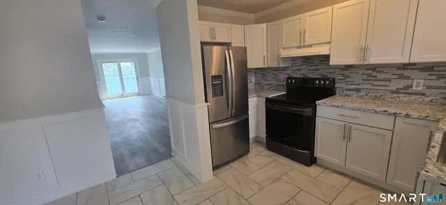 a kitchen with white cabinets and stainless steel appliances