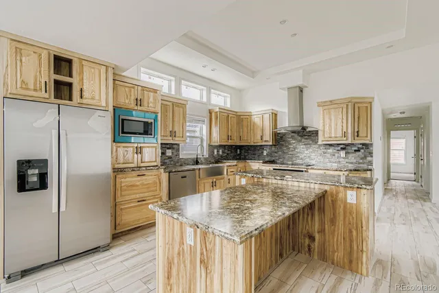 a kitchen with stainless steel appliances granite countertop a kitchen island wooden cabinets and granite counter tops