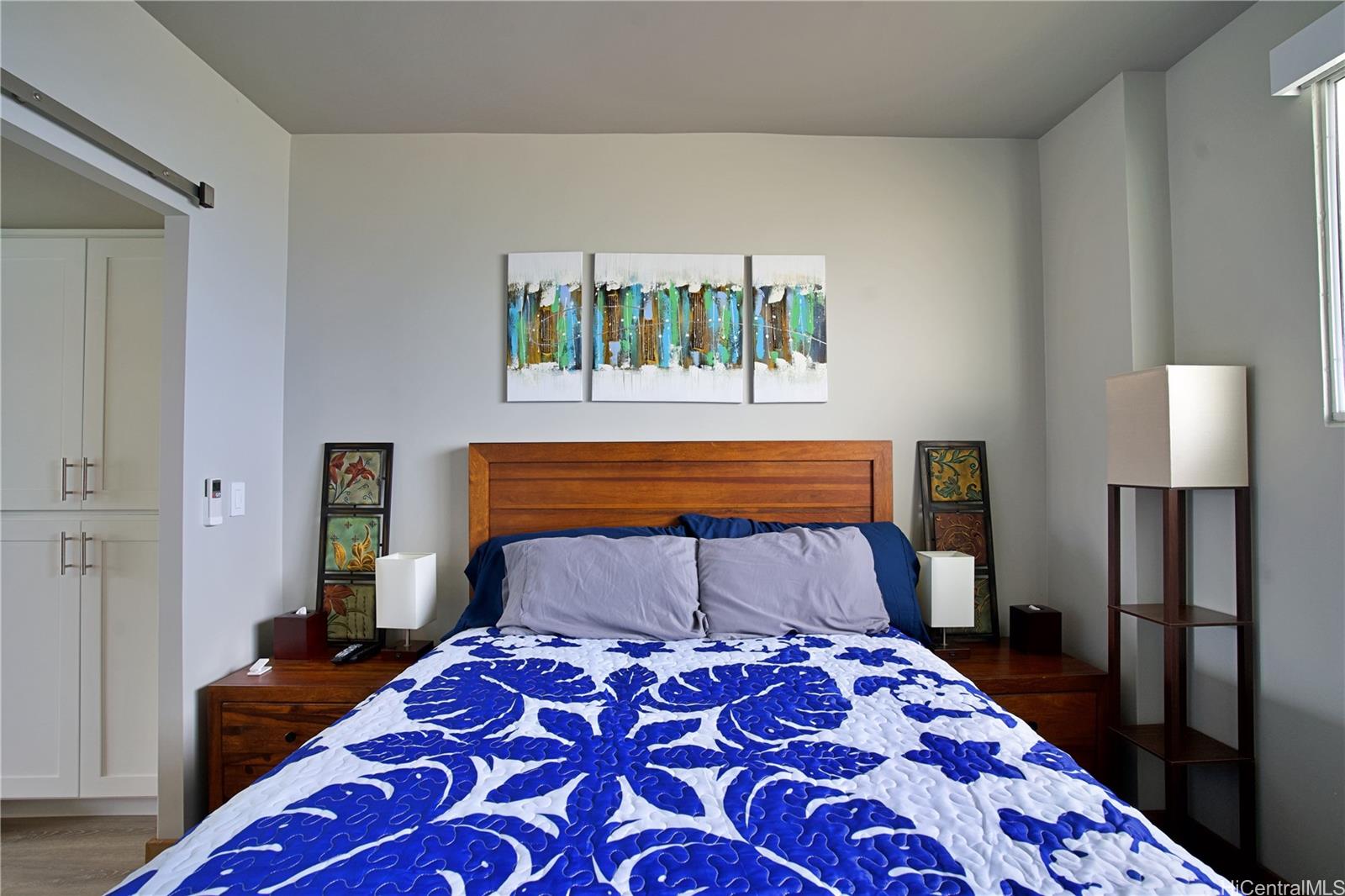 2211 Ala Wai Boulevard, Unit P6 Honolulu, HI 96815 - Photo 14 of 24 a bedroom with a bed and a lamp on dresser