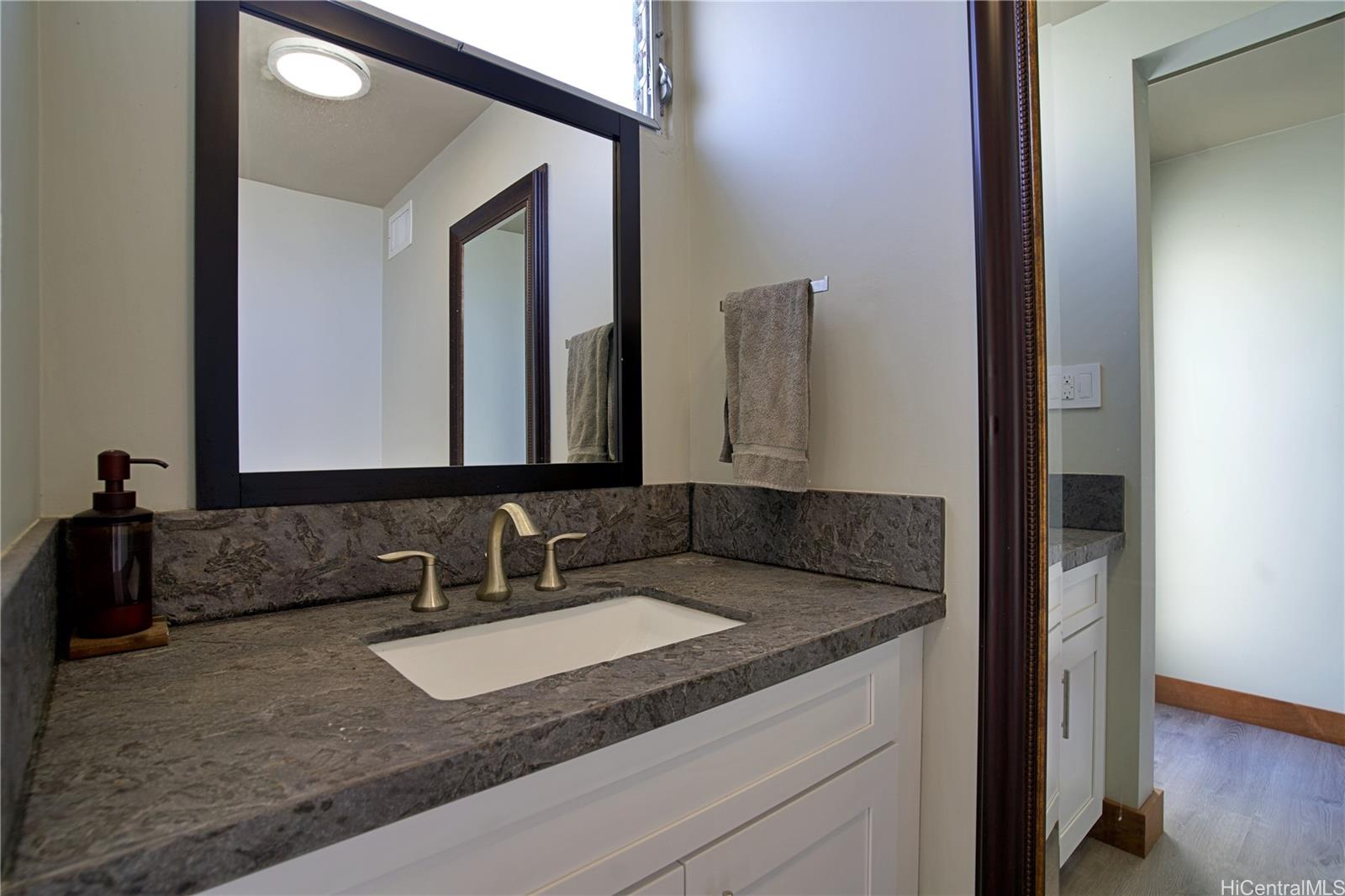 2211 Ala Wai Boulevard, Unit P6 Honolulu, HI 96815 - Photo 20 of 24 a bathroom with a granite countertop sink and a mirror