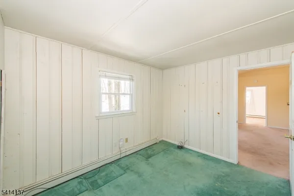 a view of an empty room with closet and a window