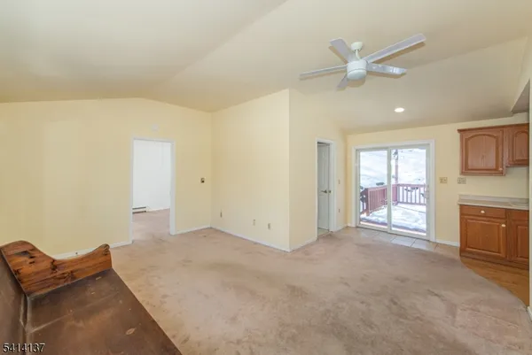 en empty room with windows and ceiling fan