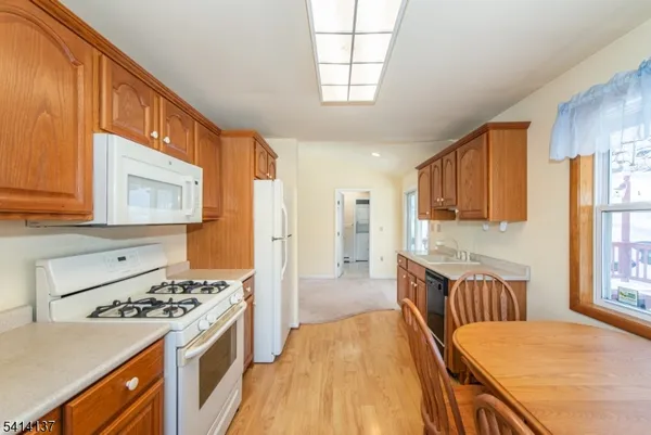 a kitchen with stainless steel appliances granite countertop a stove top oven a sink a counter space and cabinets