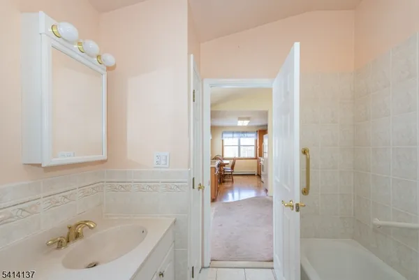 a bathroom with a tub sink and mirror