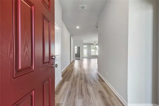 a view of a hallway with wooden floor and staircase