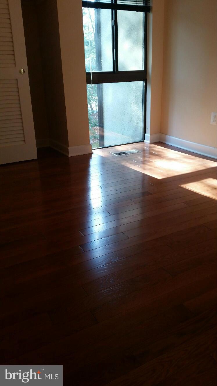 11655 Newbridge Court Reston, VA 20191 - Photo 20 of 30 a view of an empty room with wooden floor and a window