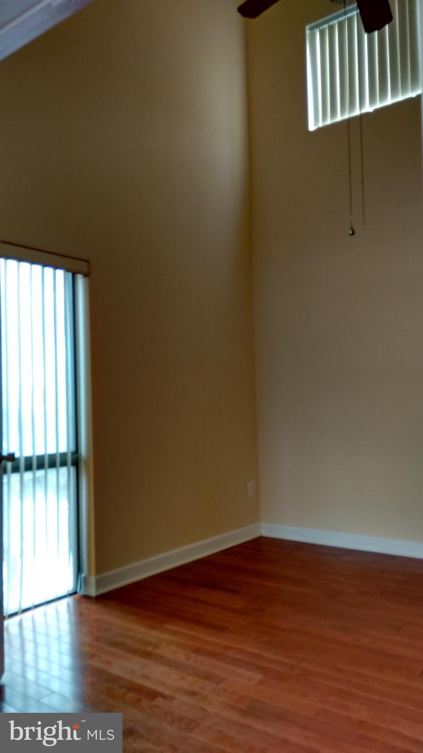 11655 Newbridge Court Reston, VA 20191 - Photo 29 of 30 a view of an empty room with wooden floor and a window