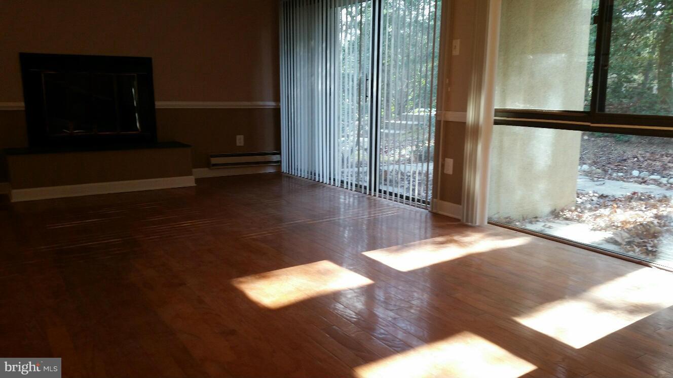 11655 Newbridge Court Reston, VA 20191 - Photo 4 of 30 a view of an empty room with wooden floor and a window