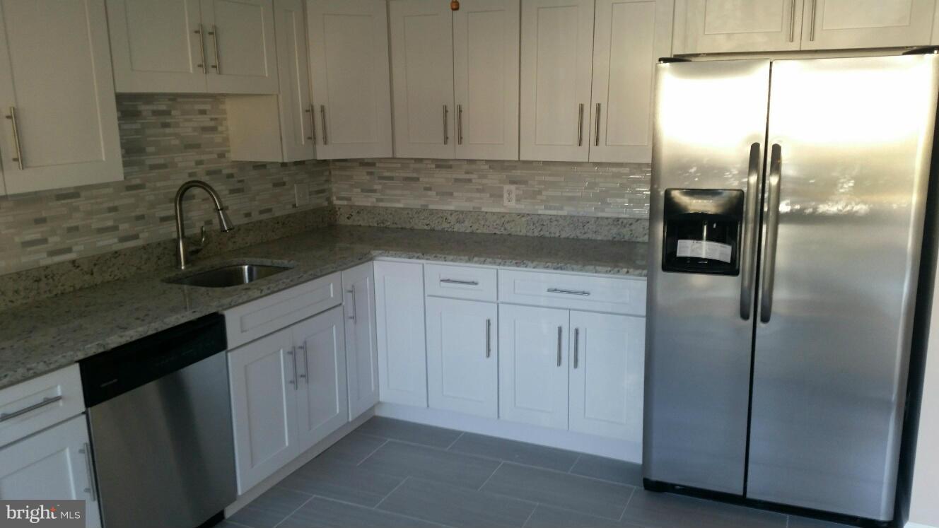 11655 Newbridge Court Reston, VA 20191 - Photo 10 of 30 a kitchen with stainless steel appliances granite countertop a refrigerator a sink and white cabinets