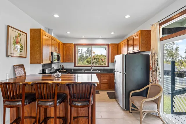 a kitchen with granite countertop a refrigerator and dining table