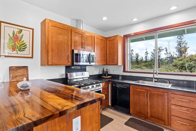 a kitchen with stainless steel appliances granite countertop a stove a sink and a microwave