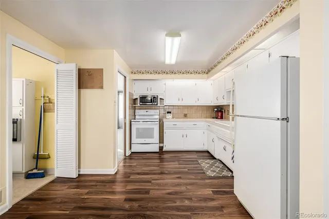 a kitchen with white cabinets and white appliances