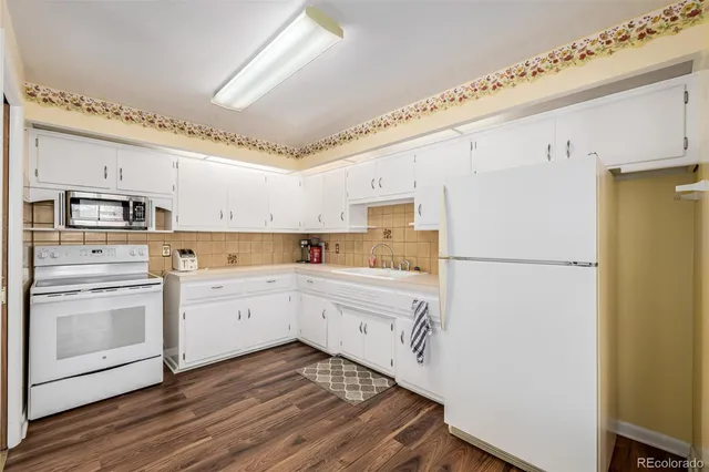 a kitchen with white cabinets and white appliances
