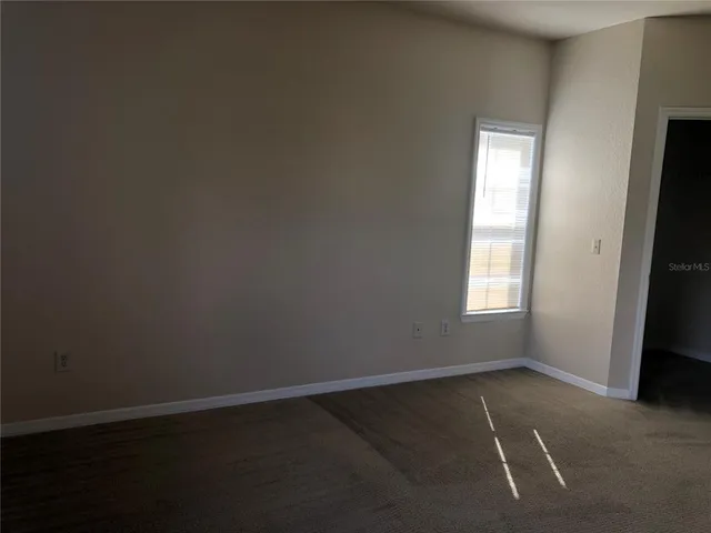 a view of a big room with windows and chandelier