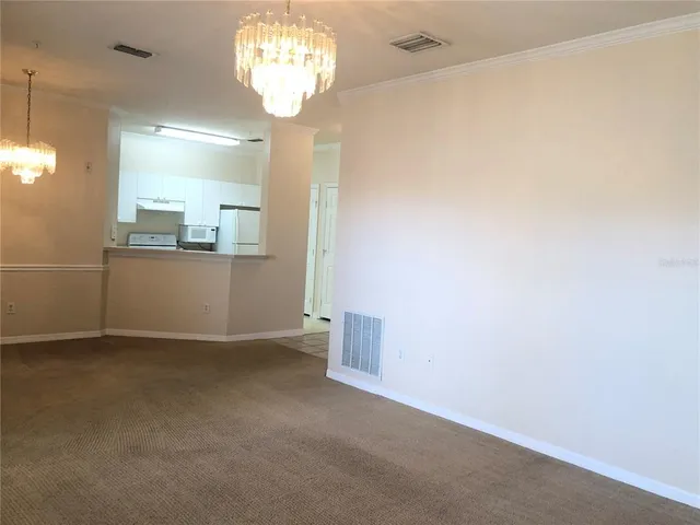 a view of a big room with windows and chandelier