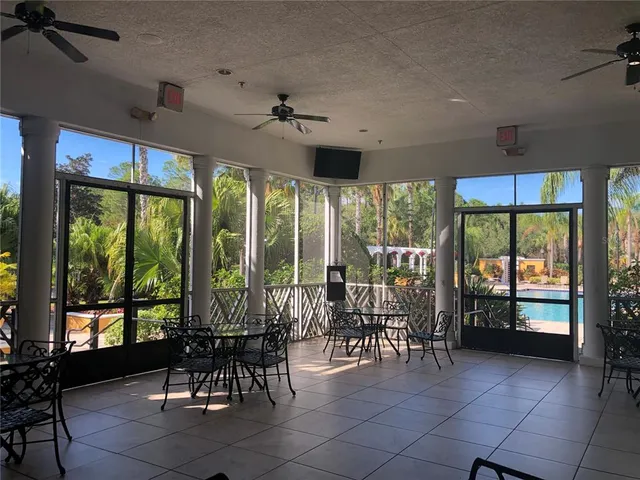 a view of a patio with dining table and chairs under an umbrella with a fireplace
