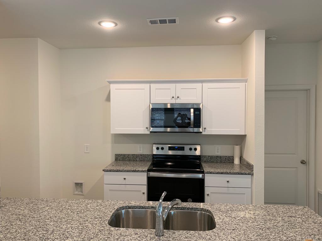 1637 Shadow Hawk Drive Fort Worth, TX 76052 - Photo 8 of 20 a kitchen with stainless steel appliances a stove and a microwave