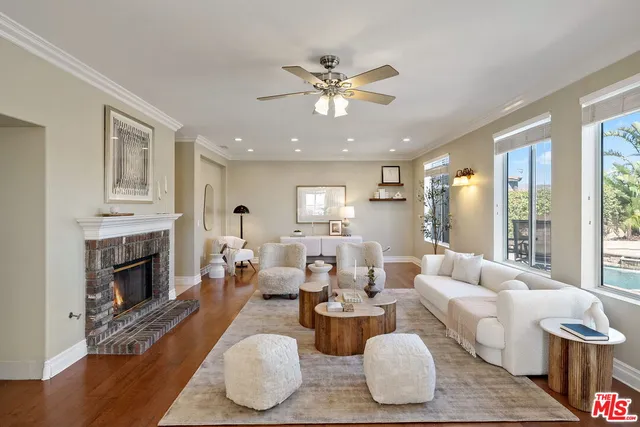 a living room with furniture fireplace and a large window