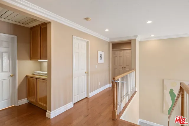 a view of hallway with furniture and wooden floor