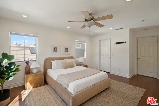 a bedroom with a bed lamp and a potted plant