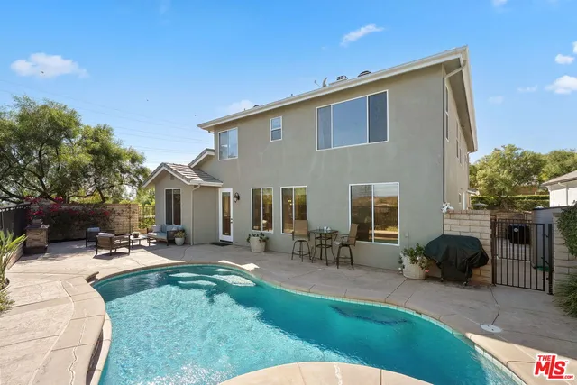 a view of a patio with table and chairs under an umbrella
