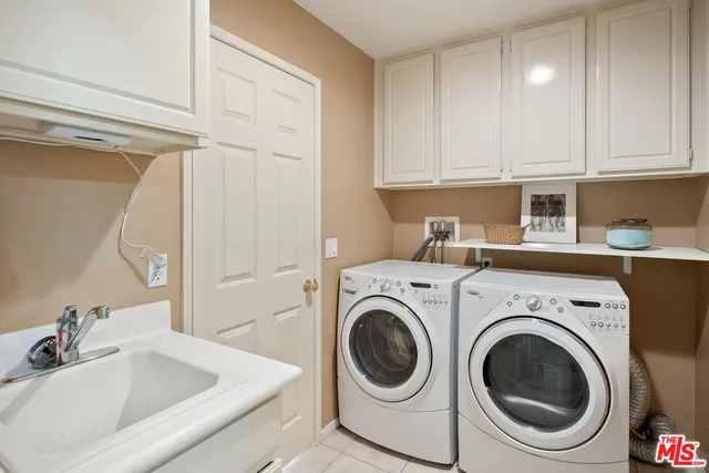 a utility room with sink dryer and washer