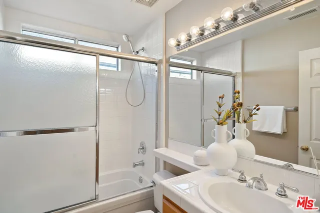 a bathroom with a bathtub shower sink vanity and toilet