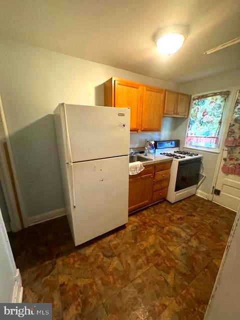 3582 Dudley Avenue Baltimore, MD 21213 - Photo 4 of 13 a kitchen with granite countertop a refrigerator a stove a sink dishwasher and wooden cabinets